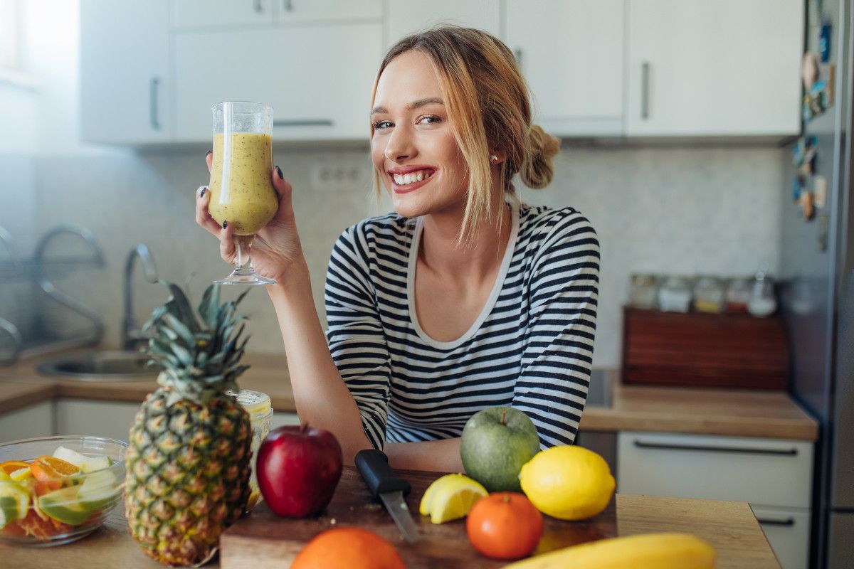 Žena drži u ruci smoothie od voća i povrća 